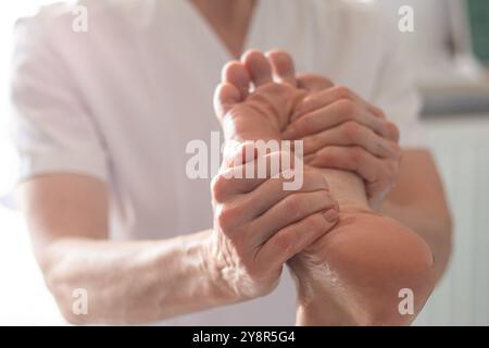Fisioterapista donna che fa un massaggio ai piedi Foto Stock