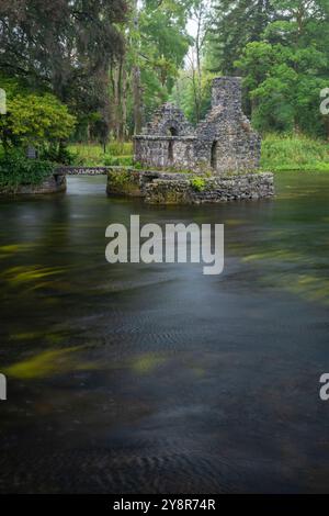 Incantevole casa di pescatori di pietra Monk sul fiume Cong a Cong Abbey, in Irlanda, in una giornata di pioggia Foto Stock