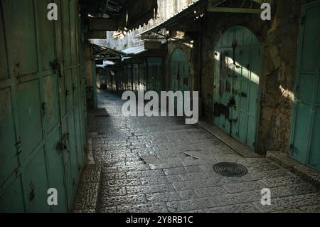 Vista mattutina della strada principale attraverso lo shuk arabo nella città vecchia di Gerusalemme prima dell'apertura dei negozi. Foto Stock