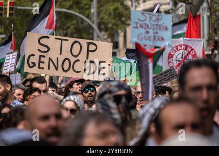 Barcellona, Spagna. 6 ottobre 2024. Il cartello di stop genocidio è visto tra una folla di manifestanti durante la manifestazione. Migliaia di persone hanno manifestato nel centro di Barcellona per chiedere un cessate il fuoco su Palestina e Libano e per chiedere al primo ministro spagnolo Pedro Sánchez di cessare immediatamente ogni collaborazione del governo spagnolo nella vendita di armi a Israele. Credito: SOPA Images Limited/Alamy Live News Foto Stock