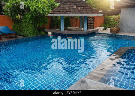 Piscina tropicale del resort con acqua cristallina e bar in piscina con area salotto ombreggiata da un piccolo padiglione sull'isola di Phi Phi, Thailandia. Lusso Foto Stock