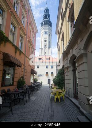 Zielona Góra, veduta del municipio da una stradina della città vecchia. Strada acciottolata, tavoli del ristorante sui marciapiedi. Foto Stock