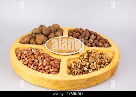 Arachidi, noci e nocciole in una scatola di legno con scomparti. Tre diversi tipi di dadi, con guscio e guscio, assortimento decorativo e pronti all'uso Foto Stock