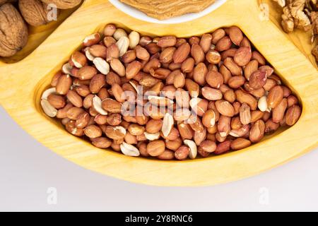 Arachidi, noci e nocciole in una scatola di legno con scomparti. Tre diversi tipi di dadi, con guscio e guscio, assortimento decorativo e pronti all'uso Foto Stock