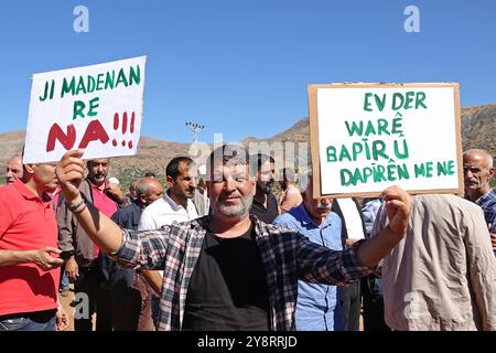 Diyarbakir, Turchia. 6 ottobre 2024. L'ecologista Bisar Icli tiene dei cartelli durante la dimostrazione. In Turchia, l'inizio dell'esplorazione mineraria da parte di una società privata nel bacino di Kasor vicino al distretto di Kulp nella provincia di Diyarbakir è stato protestato con una manifestazione cui hanno partecipato alcune organizzazioni della società civile, rappresentanti di partiti politici e amanti della natura. Credito: SOPA Images Limited/Alamy Live News Foto Stock