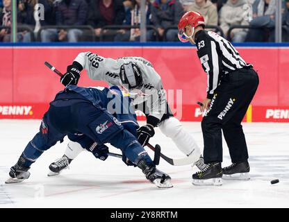 Monaco, Germania. 6 ottobre 2024. Linesperson David Tschirner fuehrt ein bully aus zwischen Ben Smith (EHC Red Bull Muenchen, n. 12) und Gregor MacLeod (Koelner Haie, n. 89). GER, EHC Red Bull Muenchen gegen Koelner Haie, Eishockey, DEL, 7. Spieltag, Saison 2024/2025, 06.10.2024. Foto: Eibner-Pressefoto/Franz Feiner credito: dpa/Alamy Live News Foto Stock