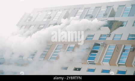 KIEV, UCRAINA - 15 NOVEMBRE 2022: Incendio nell'appartamento. Dalle finestre di un condominio proviene una spessa quantità di fumo grigio. Estinzione di un incendio in un Foto Stock