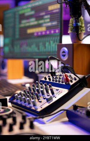 Scrivania vuota dotata di console di mixaggio e strumenti di registrazione musicale in studio domestico, attrezzatura professionale utilizzata per la produzione e la creazione di colonne sonore. Amplificatore stereo ed equalizzatore. Foto Stock