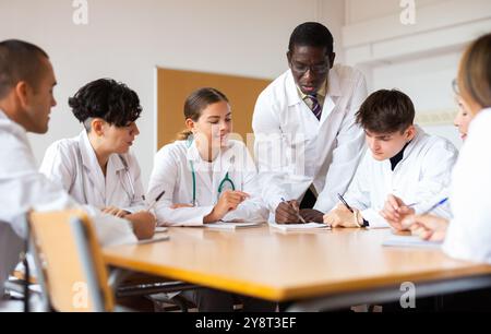 Operatori medici che ascoltano il docente afro-americano durante il corso di formazione professionale Foto Stock