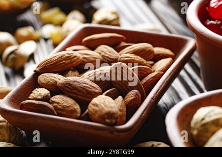 Mandorle in creta ciotola su cucina legno tavola cibo sfondo Foto Stock