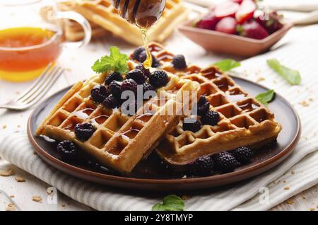 Waffle belgi croccanti fatti in casa serviti con more e miele Foto Stock