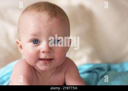 Un ragazzo si siede sul letto guardando sorpreso eccessivo un po' Foto Stock