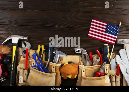 Il banner del Labor Day è un mockup di attrezzi e bandiere su sfondo di legno Foto Stock