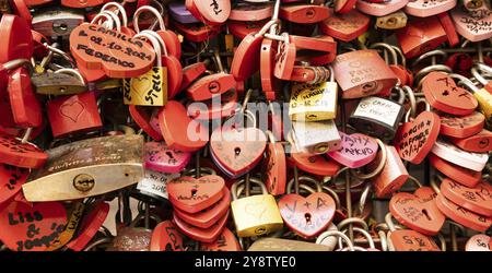 Verona, Italia, giugno 2022: Sfondo di serrature a forma di cuore su un muro, simbolo dell'amore per sempre, Europa Foto Stock