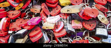 Verona, Italia, giugno 2022: Sfondo di serrature a forma di cuore su un muro, simbolo dell'amore per sempre, Europa Foto Stock