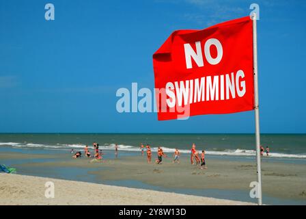 I bagnini mettono una bandiera rossa sulla riva di Myrtle Beach, South Carolina, avvertendo la gente di condizioni e correnti pericolose Foto Stock