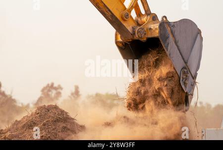Retroescavatore che lavora scavando il terreno nel cantiere benna dell'escavatore cingolato demolendo il terreno per un nuovo progetto di sviluppo di macchine movimento terra Foto Stock