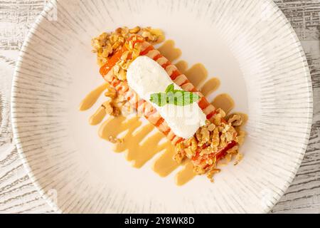 Dessert di zucca con tahini e noci su un piatto di porcellana Foto Stock