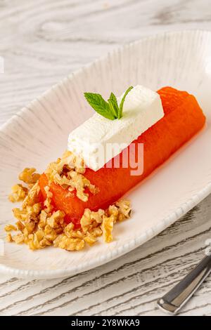 Dessert di zucca con tahini e noci su un piatto di porcellana Foto Stock