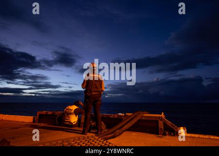 PACIFIC OCEAN (2 ottobre 2024), U.S. Navy Aviation Ordnanceman 3rd Class Joshua Harrington, da Poplar, Montana, a destra, si erge a guardare sul ponte di volo Foto Stock