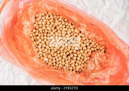 Abbondante ceci in un sacchetto di plastica, vista dall'alto con messa a fuoco selettiva Foto Stock