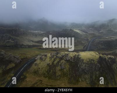 Paesaggio nebbioso con strada tortuosa attraverso le montagne Foto Stock