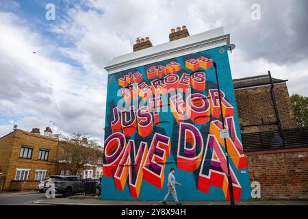 Una casa vittoriana a Brixton con le parole 'We CAN Be Heroes Just for One Day' in colorati graffiti di Street art - Londra il 29 settembre 2024. Foto Stock