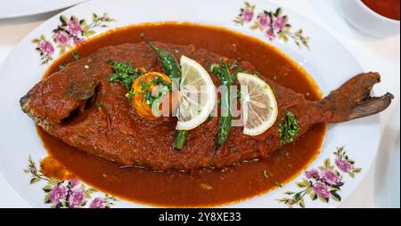 Pesce fritto ricoperto di salsa dolce e calda sul piatto. Pesce cotto con salsa di pomodoro o curry di pesce. Pesce intero in stile thailandese preparato al momento. Nessuno Foto Stock