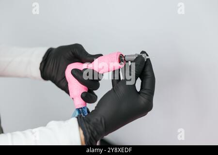 Primo piano delle mani del cosmetologo che preparano gli strumenti per la micropigmentazione permanente dell'eyeliner in un ambiente pulito e sterile del salone cosmetico Foto Stock