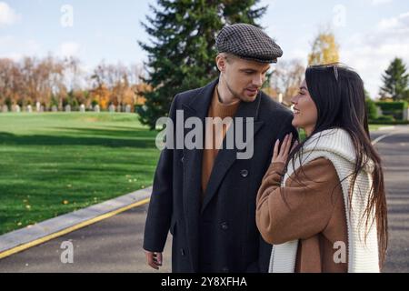 Una coppia amorevole gode di un momento intimo mentre cammina attraverso un pittoresco paesaggio autunnale. Foto Stock