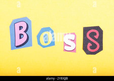 Frase Boss scritta in tipografia ritagliata in stile giornale, isolata su sfondo giallo. Foto Stock