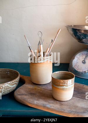 Splendida composizione artigianale di ceramiche, tazze, ciotole e utensili su un armadietto blu, fatto a mano in francia, stile rustico Foto Stock