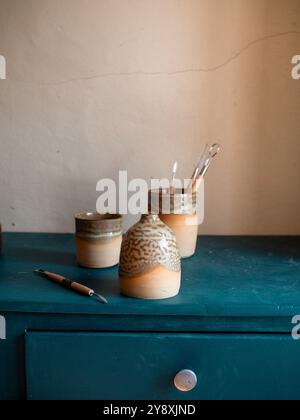 Splendida composizione artigianale di ceramiche, tazze, ciotole e utensili su un armadietto blu, fatto a mano in francia, stile rustico Foto Stock