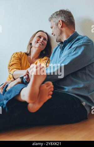 Una coppia felice si diverte a casa mentre si siede sul pavimento. Foto di alta qualità Foto Stock