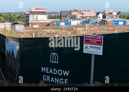 Fossetts Way, Southend on Sea, Essex, Regno Unito. 7 ottobre 2024. Sono in corso lavori di demolizione di case costruite utilizzando una tecnica di costruzione «flat pack», iniziata nel novembre 2022. I lavori si fermarono nel giugno 2023 a seguito del crollo del costruttore modulare Ilke Homes che aveva utilizzato la tecnica per completare parzialmente 32 di un progetto pianificato di 221 case Meadow Grange. Gli edifici hanno subito danni atmosferici e problemi di sicurezza antincendio nella misura in cui la Guinness Partnership, l'associazione degli alloggi che ha lasciato le case, ha scelto di iniziare a costruire da zero Foto Stock