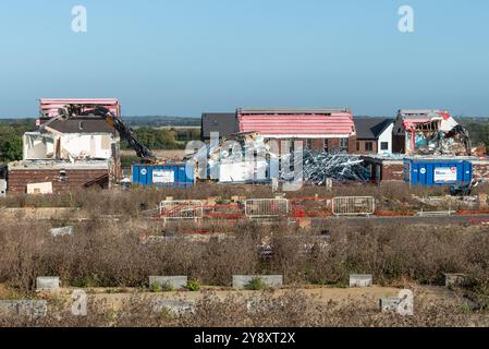 Fossetts Way, Southend on Sea, Essex, Regno Unito. 7 ottobre 2024. Sono in corso lavori di demolizione di case costruite utilizzando una tecnica di costruzione «flat pack», iniziata nel novembre 2022. I lavori si fermarono nel giugno 2023 a seguito del crollo del costruttore modulare Ilke Homes che aveva utilizzato la tecnica per completare parzialmente 32 di un progetto pianificato di 221 case Meadow Grange. Gli edifici hanno subito danni atmosferici e problemi di sicurezza antincendio nella misura in cui la Guinness Partnership, l'associazione degli alloggi che ha lasciato le case, ha scelto di iniziare a costruire da zero Foto Stock