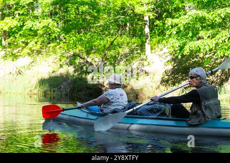 Gita in kayak per famiglie per il signore e senora. Una coppia sposata anziana che canoa una barca sul fiume, un'escursione in acqua, un'avventura estiva. Sport legati all'età, Foto Stock