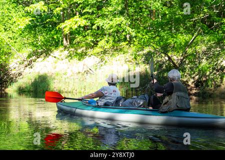 Gita in kayak per famiglie per il signore e senora. Una coppia sposata anziana che canoa una barca sul fiume, un'escursione in acqua, un'avventura estiva. Sport legati all'età, Foto Stock