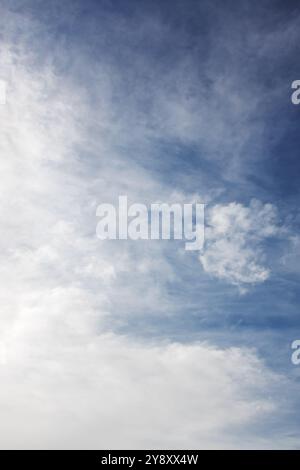 Il cielo è una bella tonalità di blu con soffici nuvole bianche sparse su di esso, creando un tranquillo paesaggio naturale Foto Stock