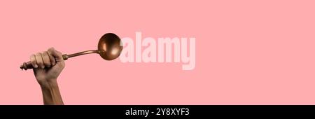 Uomo nero che regge un mestolo da cucina vintage in ottone su striscione rosa Foto Stock