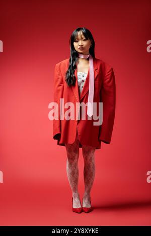 Una donna elegante sfoggia un look audace con un blazer rosso oversize, che trasuda fiducia e fascino. Foto Stock