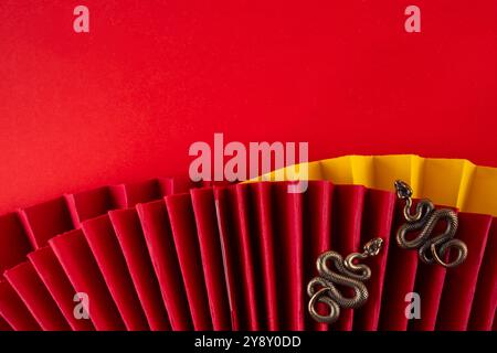 Capodanno cinese asia sfondo rosso dorato. Nuovo biglietto d'auguri per l'anno zodiaco Snake 2025. Sfondo piatto rosso con ventole natalizie, buste dei desideri, n. di serie Foto Stock