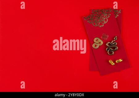 Capodanno cinese asia sfondo rosso dorato. Nuovo biglietto d'auguri per l'anno zodiaco Snake 2025. Sfondo piatto rosso con ventole natalizie, buste dei desideri, n. di serie Foto Stock