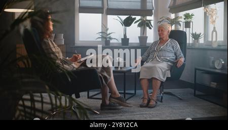 Sessione di terapeuta con paziente anziano in ufficio. Una donna anziana parla di problemi familiari e condivide sentimenti. Psicologa o psicoterapeuta femminile supporta il paziente, convalida le emozioni. Psicologia. Foto Stock