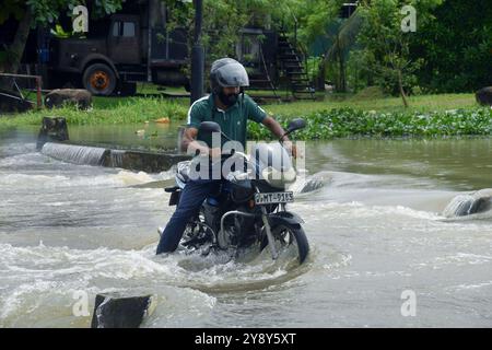 Colombo, Sri Lanka. 7 ottobre 2024. Un uomo guida una moto attraverso una strada allagata dopo forti piogge nel sobborgo di Colombo, Sri Lanka, 7 ottobre 2024. Crediti: Ajith Perera/Xinhua/Alamy Live News Foto Stock