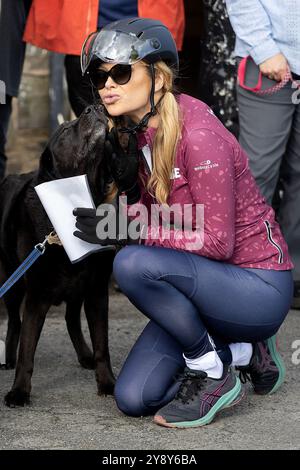 Ashreigney, Regno Unito. 7 ottobre Pucker su! Amanda Holden fa amicizia con un cane, il primo giorno del suo giro in bici di 250 miglia da Bude a Londra, per raccogliere fondi per la campagna Make Some Noise della Global. La star del programma televisivo Britain’s Got Talent and Heart Breakfast mira a completare il giro in bicicletta in cinque giorni, finendo al Heart HQ, a Leicester Square, Londra. Credito: Mark Passmore/Alamy Live News Foto Stock