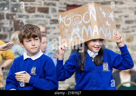 Ashreigney, Regno Unito. 7 ottobre Schoolchrildren della Dolton Primary School augurano buona fortuna ad Amanda Holden per il primo giorno della sua corsa in bici da 250 Mile da Bude a Londra, per raccogliere fondi per la campagna Make Some Noise della Global. La star del programma televisivo Britain’s Got Talent and Heart Breakfast mira a completare il giro in bicicletta in cinque giorni, finendo al Heart HQ, a Leicester Square, Londra. Credito: Mark Passmore/Alamy Live News Foto Stock