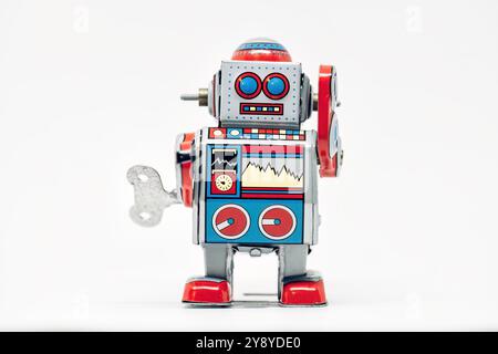 Il robot giocattolo vintage su sfondo bianco evoca la nostalgia dell'infanzia con un colorato design retrò e dettagli meccanici, incarnando la fantascienza Foto Stock