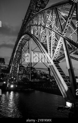 Dettaglio architettonico dell'iconico ponte ad arco in ferro Ponte Luis i nel centro di Porto di notte, Portogallo Foto Stock