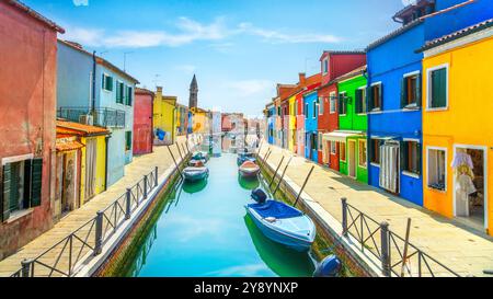Canale dell'isola di Burano, case colorate e barche nella laguna di Venezia, il campanile della chiesa sullo sfondo. Regione Veneto, Italia, Europa Foto Stock